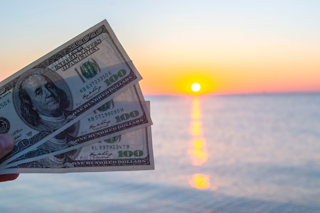 Billetes de trescientos dólares en el fondo de la superficie del mar al amanecer al atardecer