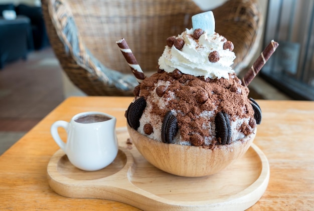 Bingsu postre helado de chocolate y crema batida en bandeja de madera