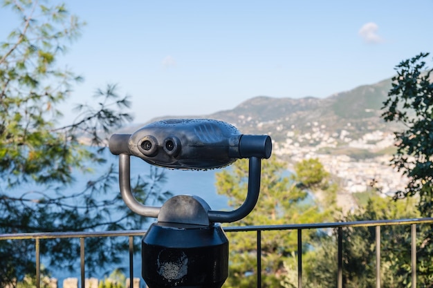 Binoculares estacionarios a prueba de vandalismo con un aceptador de monedas en un lugar turístico