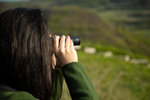 Binoculares de mano mujer sorprendida en la naturaleza