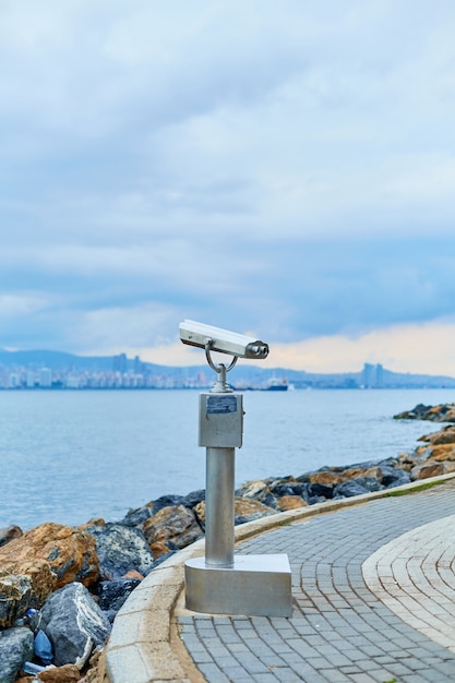 Foto binóculos de turismo turístico no calçadão da ilha de buyukada com vista para istambul