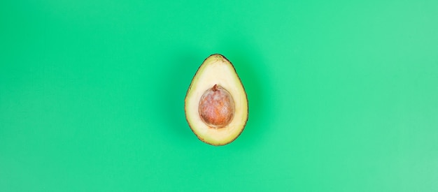 Bio-Avocado mit Samen auf grünem Hintergrund