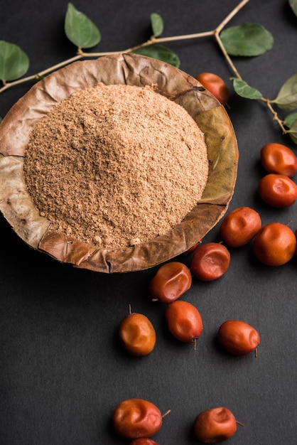 Bio-Borkut-Pulver aus indischer Jujube-Bere oder -Beere oder Ziziphus mauritiana, einer Dattelart. Über stimmungsvollem Hintergrund, selektiver Fokus