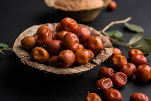 Bio-Borkut-Pulver aus indischer Jujube-Bere oder -Beere oder Ziziphus mauritiana, einer Dattelart. Über stimmungsvollem Hintergrund, selektiver Fokus