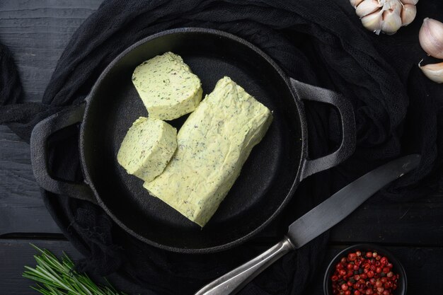 Bio-Butter mit einem Kraut für Sandwiches und Steak-Set, auf schwarzem Holztisch