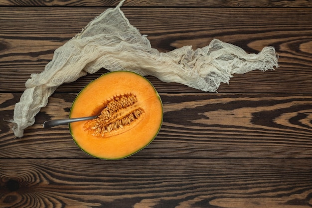 Bio-Cantaloupe-Melonenscheiben auf einem Holzschneidebrett mit Samen, Draufsicht, Kopienraum, Holzhintergrund