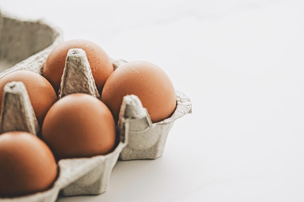 Bio-Eier in Eierbox auf weißem Marmor Küchentisch, Nahaufnahme