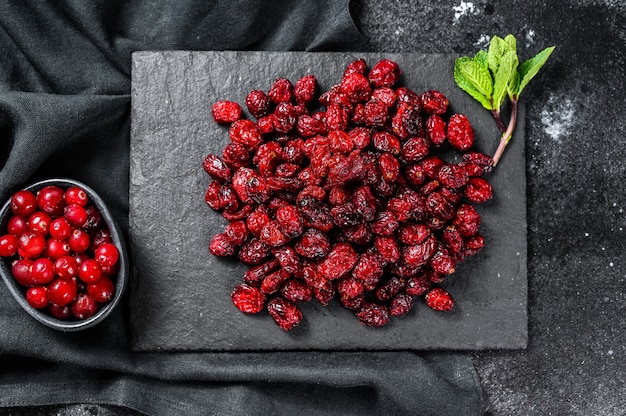 Bio getrocknete Preiselbeeren auf einem Steinbrett