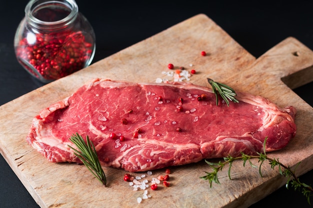 Bio-Glasfutter rohes Fleischfilet-Rindersteak auf schwarzem Schiefersteintisch