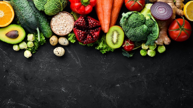 Bio-Lebensmittel auf schwarzem Steinhintergrund Gemüse und Obst Draufsicht Kostenloser Kopierbereich