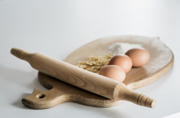 Bio-Lebensmittel. rohe Nudeln, Eier und Mehl auf einem Holzbrett