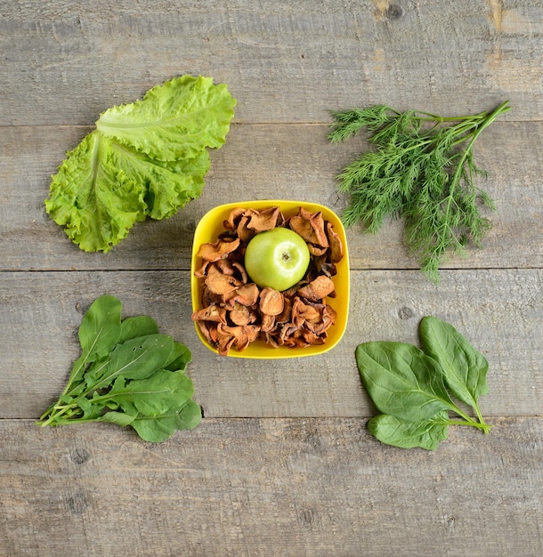 Bio-LebensmittelRahmen aus Zutaten für Saladon und trockene Äpfel auf altem rustikalem Holztisch