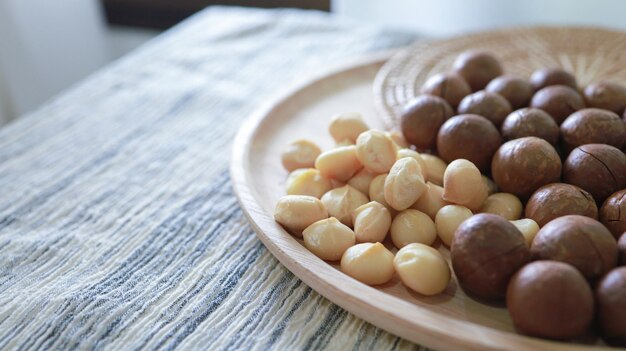 Foto bio-macadamia-nüsse: macadamianüsse werden geknackt und gebacken, um ein äußerst köstliches superfood zu schmecken. frische, natürliche, geschälte macadamia und gesundes lebensmittelkonzept