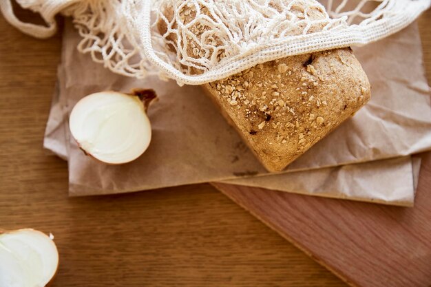 Bio-Sauerteig ungesäuertes Zwiebelbrot mit Haferflocken auf Bastelpapier Laib aus natürlichem, frisch gebackenem Brot Beige rustikaler Lebensmittelhintergrund