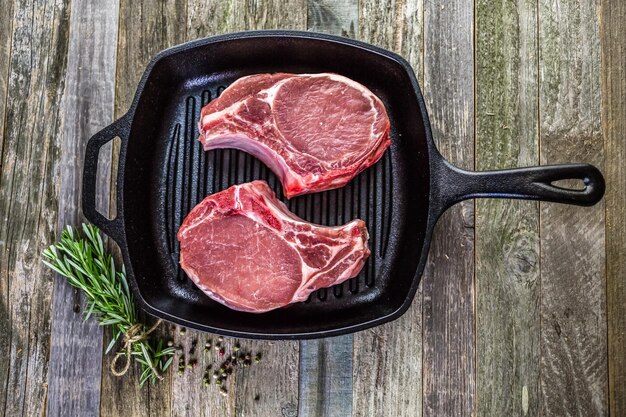 Bio-Schweinekoteletts aus dickem Schnitt in einer gusseisernen Bratpfanne.