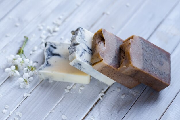 Foto bio-seifenstücke und blütenblätter auf dem weißen holzschreibtisch