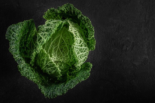 Bio-Wirsingkohl auf schwarzem Hintergrund gesundes veganes Essen Draufsicht mit Kopierraum