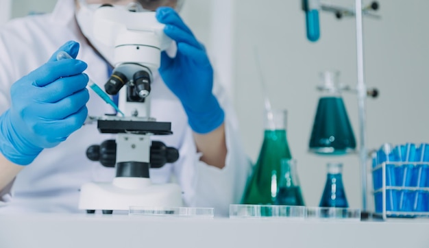 Biochemisches Forscherteam, das mit einem Mikroskop für die Entwicklung von Coronavirus-Impfstoffen im selektiven Fokus des pharmazeutischen Forschungslabors arbeitet