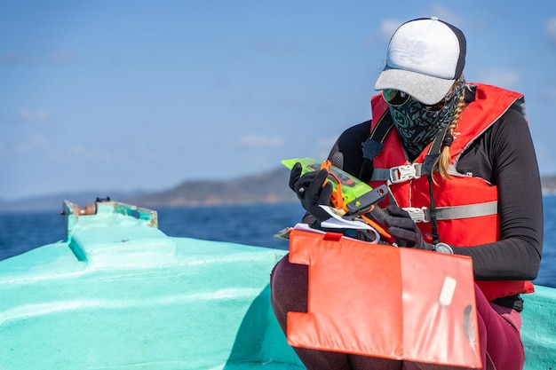 Bióloga marinha feminina trabalhando sentada em um barco