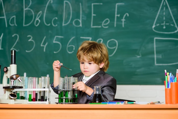 Biología ciencia ciencia experimentos con microscopio en laboratorio escuela niño científico estudiando ciencia El niño pequeño está haciendo experimentos científicos niño pequeño en la lección Regreso a la escuela Investigaciones científicas