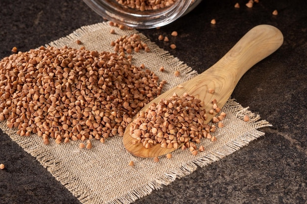 Foto biologischer buchweizenbrei mit holzlöffel auf rustikaler lappen serviette