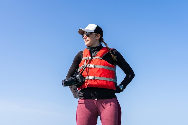 Biólogo marino parado en un bote con una cámara digital