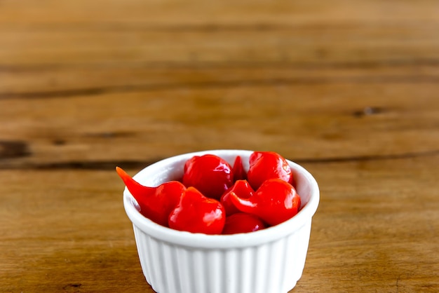 Biquinho Peppers Pimiento dulce brasileño Capsicum chinense sobre mesa de madera