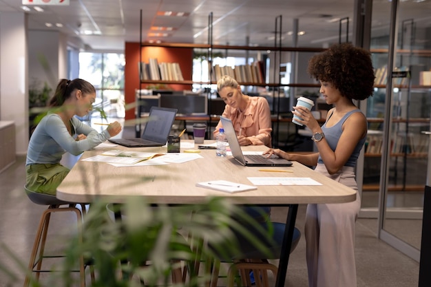 Biracial-Beraterinnen arbeiten am Tisch an einem modernen Arbeitsplatz