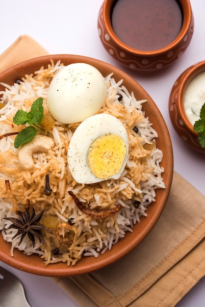 Biryani de huevo - Arroz basmati cocinado con huevos asados masala y especias y servido con yogur, enfoque selectivo