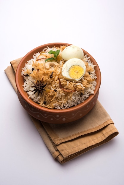 Biryani de huevo - Arroz basmati cocinado con huevos asados masala y especias y servido con yogur, enfoque selectivo