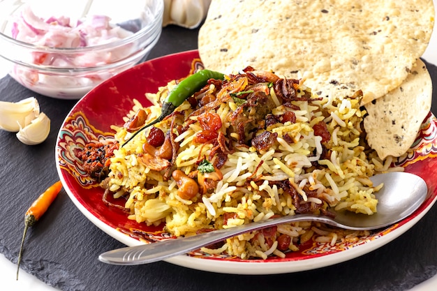 Biryani indiano com acompanhamentos, alhos e pimenta