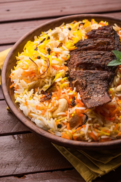 Biryani de pescado o arroz de pescado: receta popular no vegetariana de la India hecha de pescado marinado con especias indias, hierbas frescas y cocido con arroz basmati, enfoque selectivo