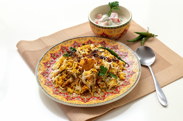 Foto biryani de pollo indio halal servido con yogurt tomate raita