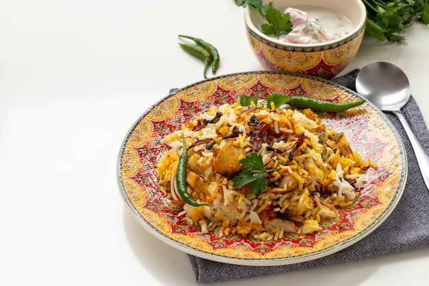 Foto biryani de pollo indio halal servido con yogurt tomate raita