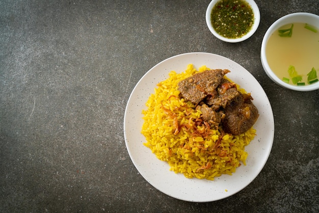 Biryani de ternera o arroz al curry y ternera - versión tailandesa-musulmana del biryani indio, con fragante arroz amarillo y ternera - estilo de comida musulmana