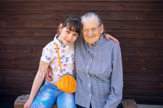 Bisabuela y bisnieta sentadas del brazo.