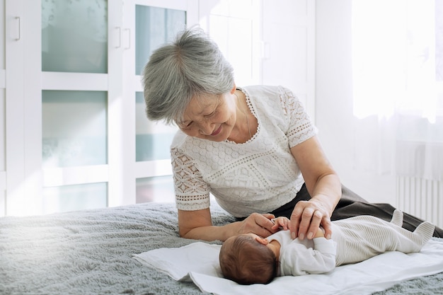 Foto la bisabuela juega con una bisnieta recién nacida.