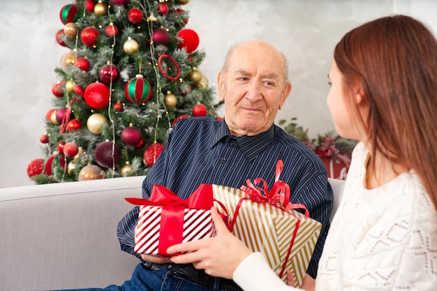 Bisavô e bisneta avô recebendo presente de natal da neta