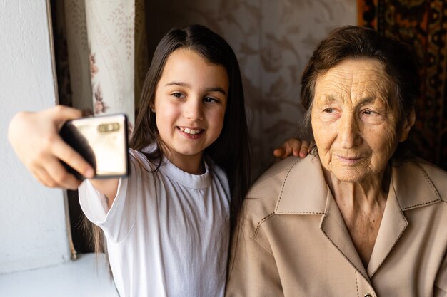 bisavó e neta muito velhas com um smartphone online