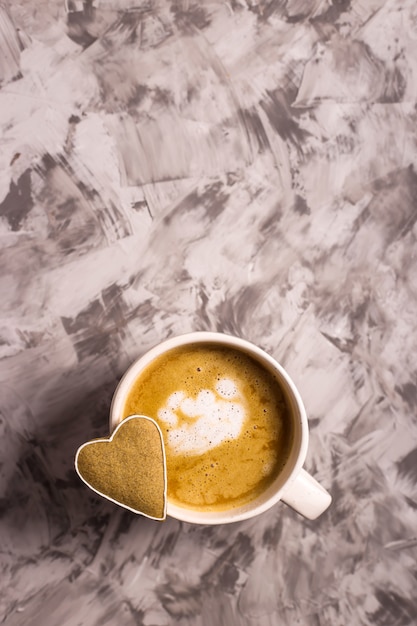 Biscoito caseiro de gengibre em forma de um coração em um copo de cappuccino