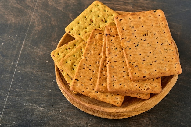 Biscoito com sementes de linho e forma retangular de farelo de aveia na mesa de madeira escura. Lanche para uma nutrição adequada.