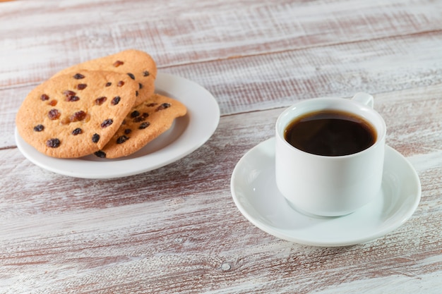 Biscoito de chocolate e chá em uma mesa de madeira