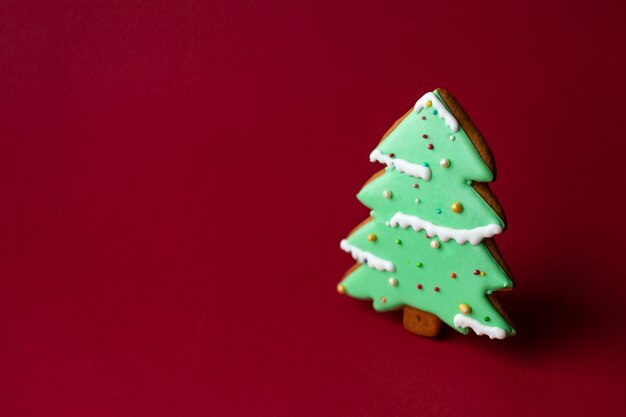 Biscoito de gengibre da árvore de Natal verde no vermelho. Comida tradicional de Natal. Feriado de Natal e ano novo. Copyspace