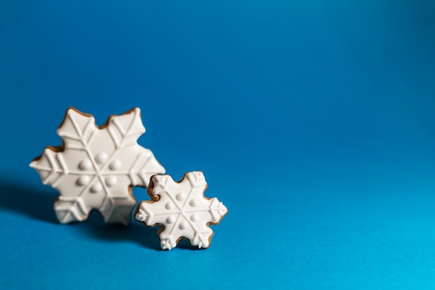 Biscoito de gengibre de floco de neve sobre fundo azul.