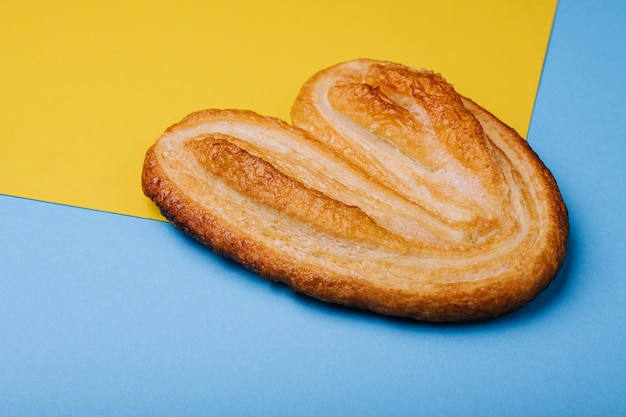 Biscoito de massa folhada em fundo azul e amarelo