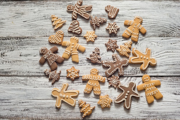 Biscoito de natal e doces na madeira, vista superior dos alimentos. presentes com papel artesanal. texto.