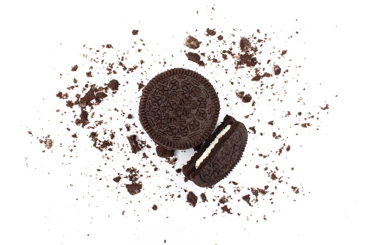Foto biscoito de sanduíche de chocolate ao leite com 1 comido, isolado com migalhas de biscoito