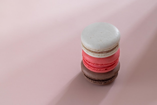 Foto biscoitos biscoitos multicoloridos em um fundo rosa de rosa marrom escuro e bege com sombras