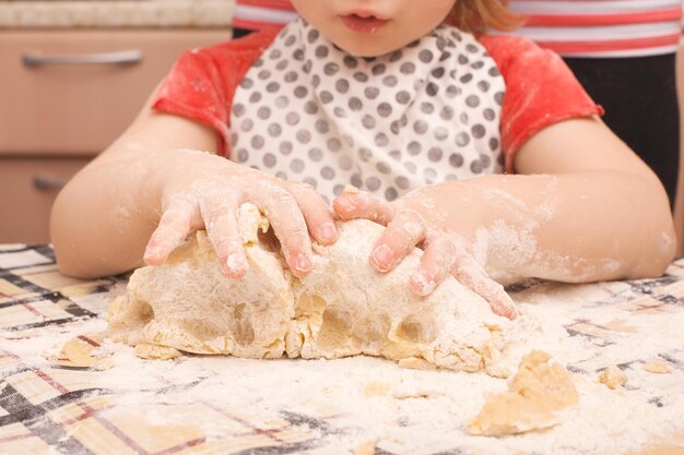 Biscoitos caseiros com passas em cima da mesa. A filha ajuda a mãe a cozinhar.