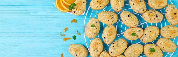 Biscoitos caseiros. cookies franceses madeleines com suco de laranja e lascas de chocolate. bandeira.